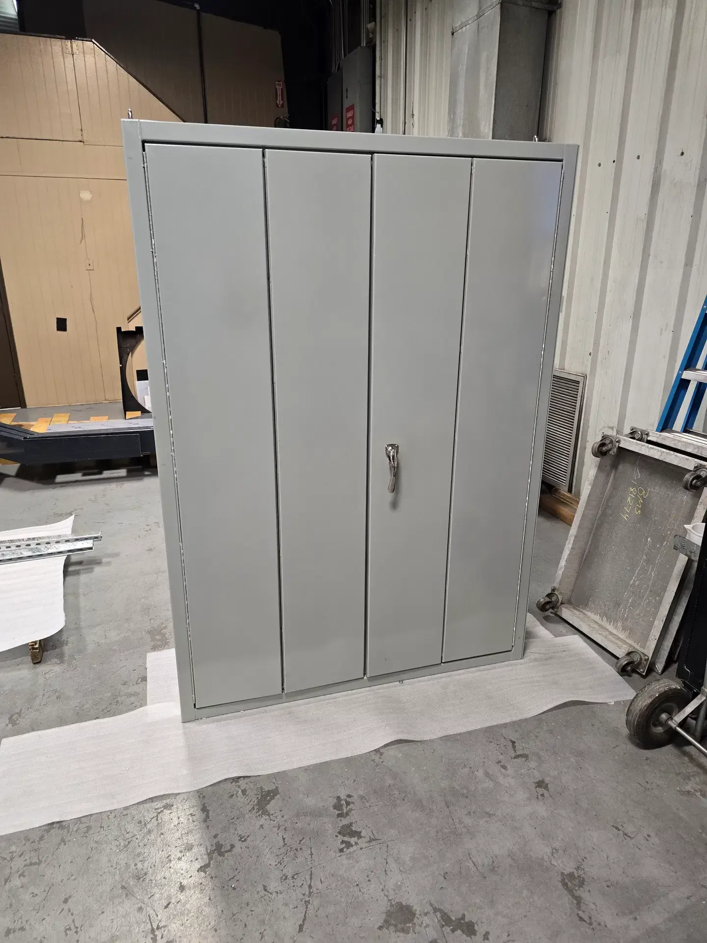 Painted steel industrial storage cabinet with reinforced double doors and locking hardware